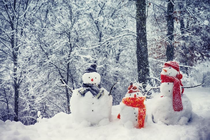 Three snowmen wearing bright scarves and hats.