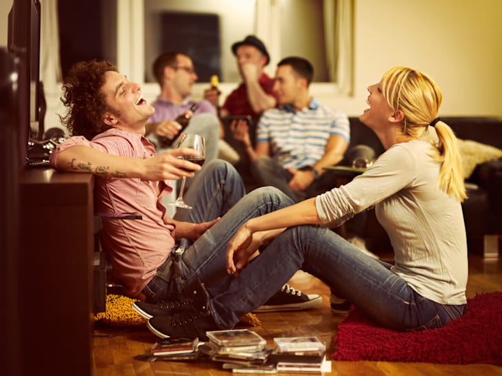 adults drinking wine in the living room