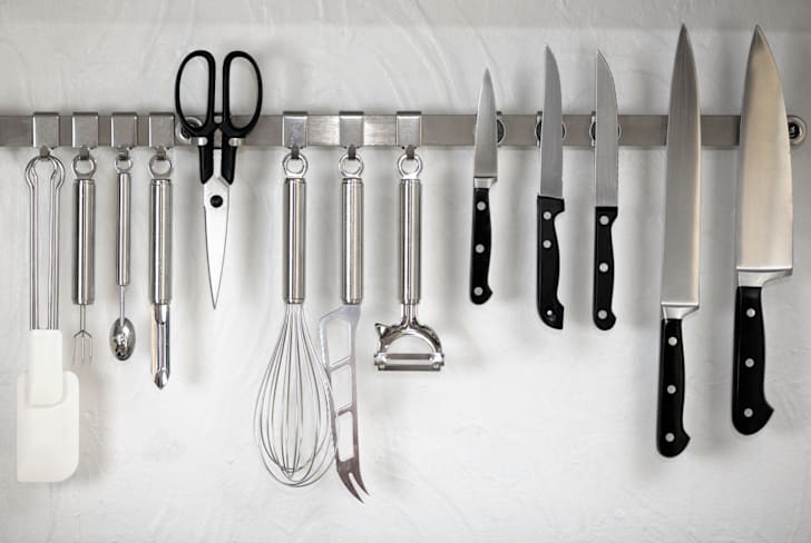 Row of hanging kitchen knives and utensils.
