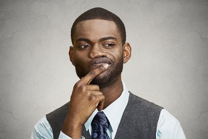 A skeptical-looking man with a finger on his lower lip