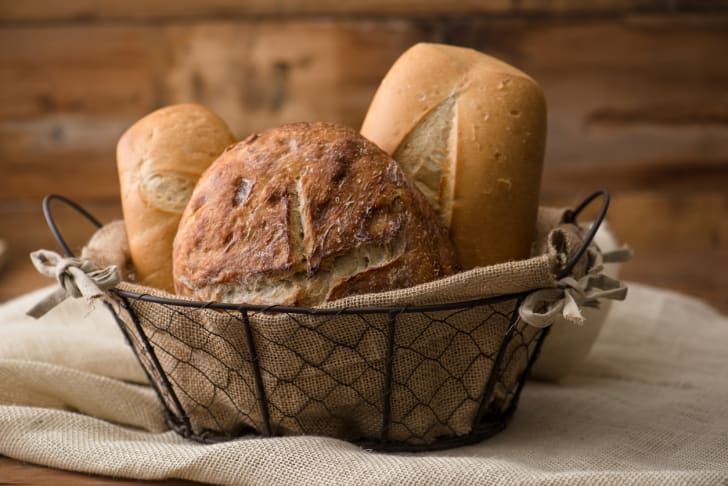 Three loaves of bread in a wire basket.
