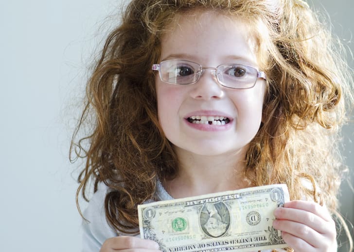 A little girl with money she received for losing a tooth.
