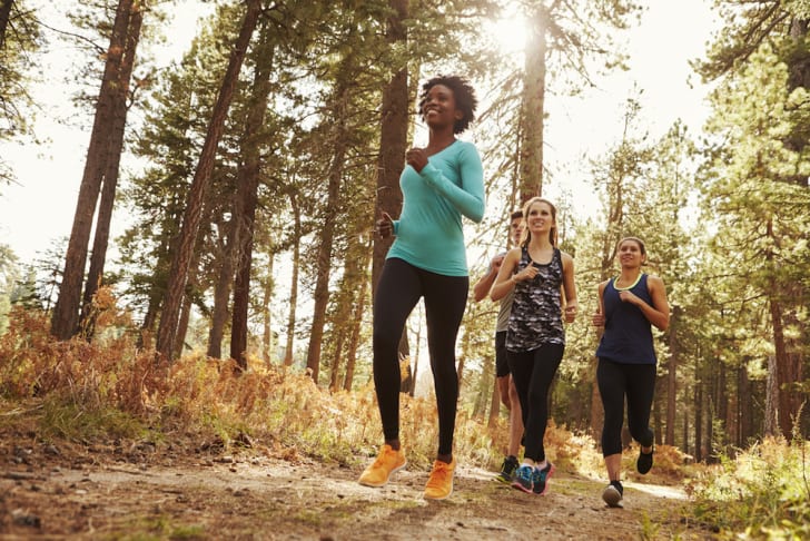 A group of people jogging in the woods