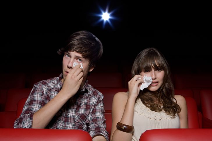 man and woman crying in movie theater