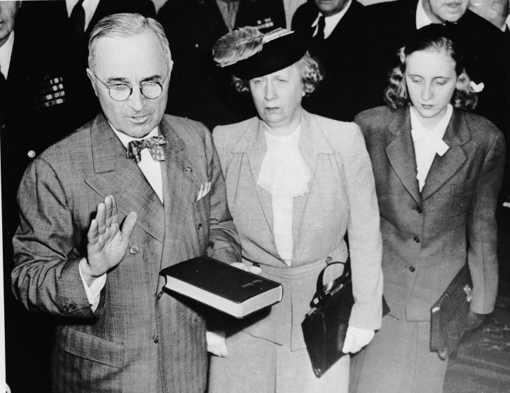Harry Truman takes the oath of office in 1945; standing beside him are his wife, Bess, and daughter, Margaret.