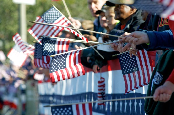 People holding American flags at Veterans Day Parade.