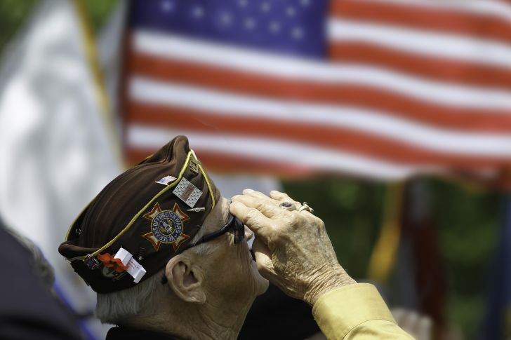 Senior veteran saluting at flag.