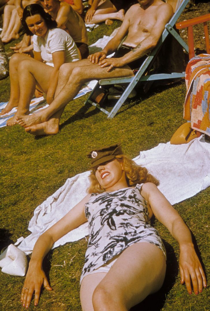 A British servicewoman sunbathing in her swimsuit and uniform cap, circa 1942.