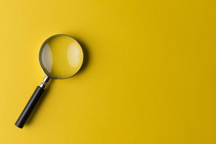 A magnifying glass on a yellow background.