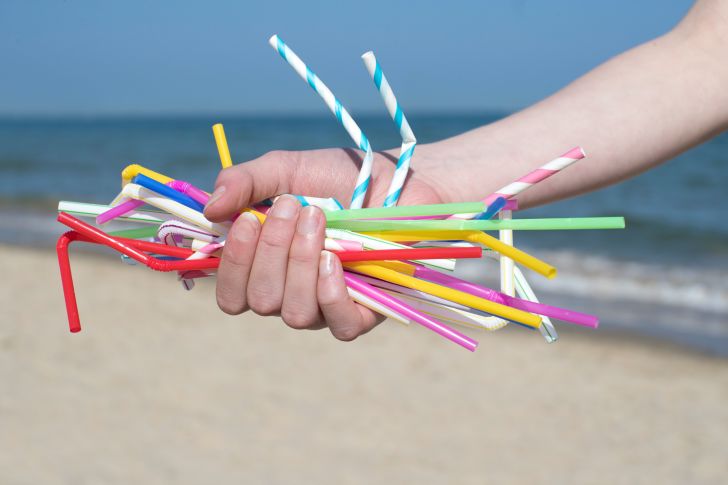 Someone grasping a handful of plastic straws