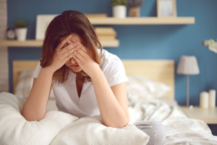 Woman looking tired and unwell in bed