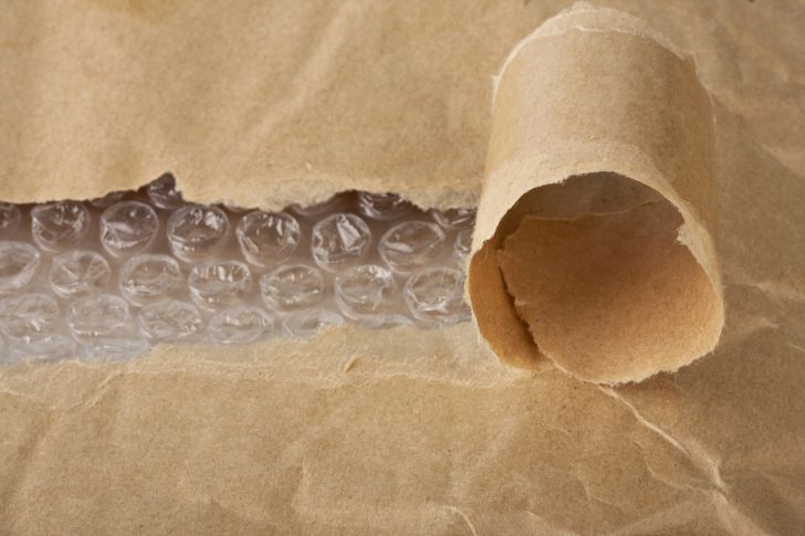 Curl of brown paper over Bubble Wrap.