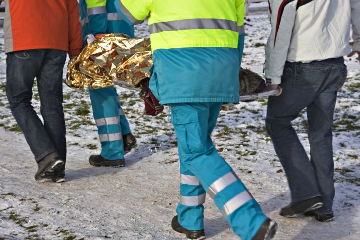 Emergency responders carrying a stretcher in the snow.