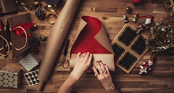 A picture of a woman's hands wrapping a christmas present.