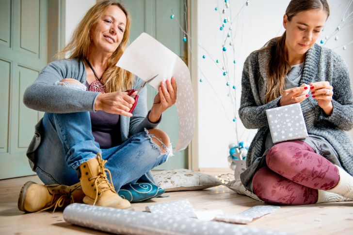 A mother and daughter wrapping presents.