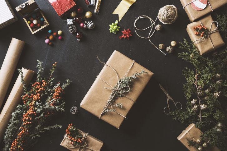 A present wrapped in plain paper and twine with a twig as an embellishment.