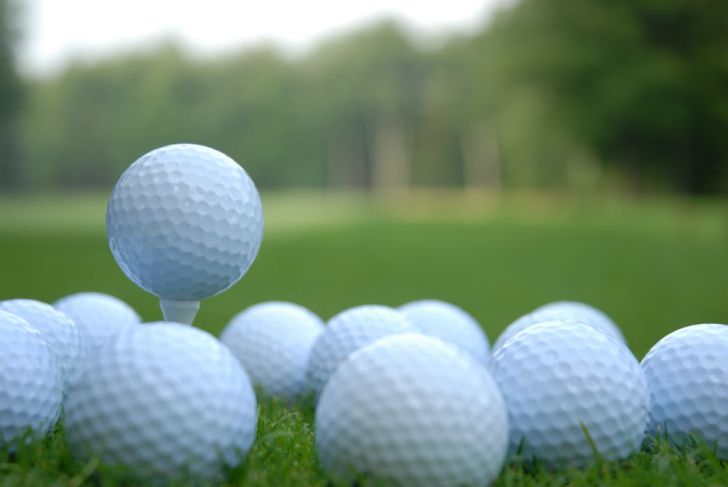 Golf balls are piled up on a golf course