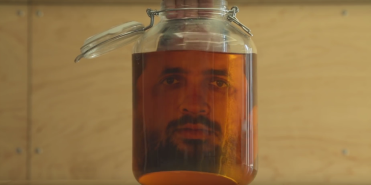 A photograph of a face appears in a jar