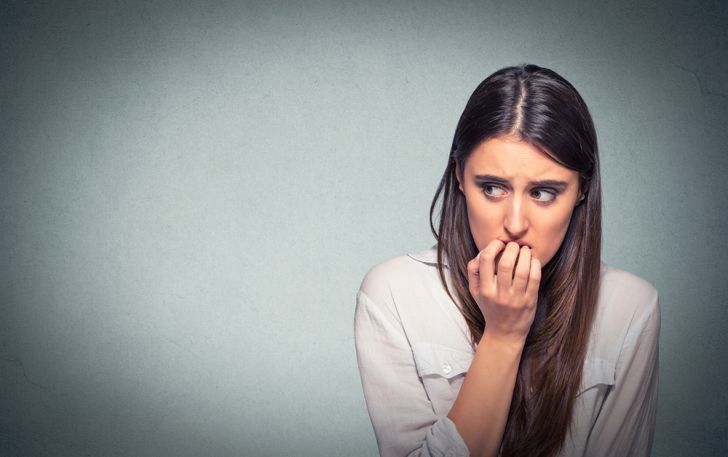 Young nervous woman biting fingernails