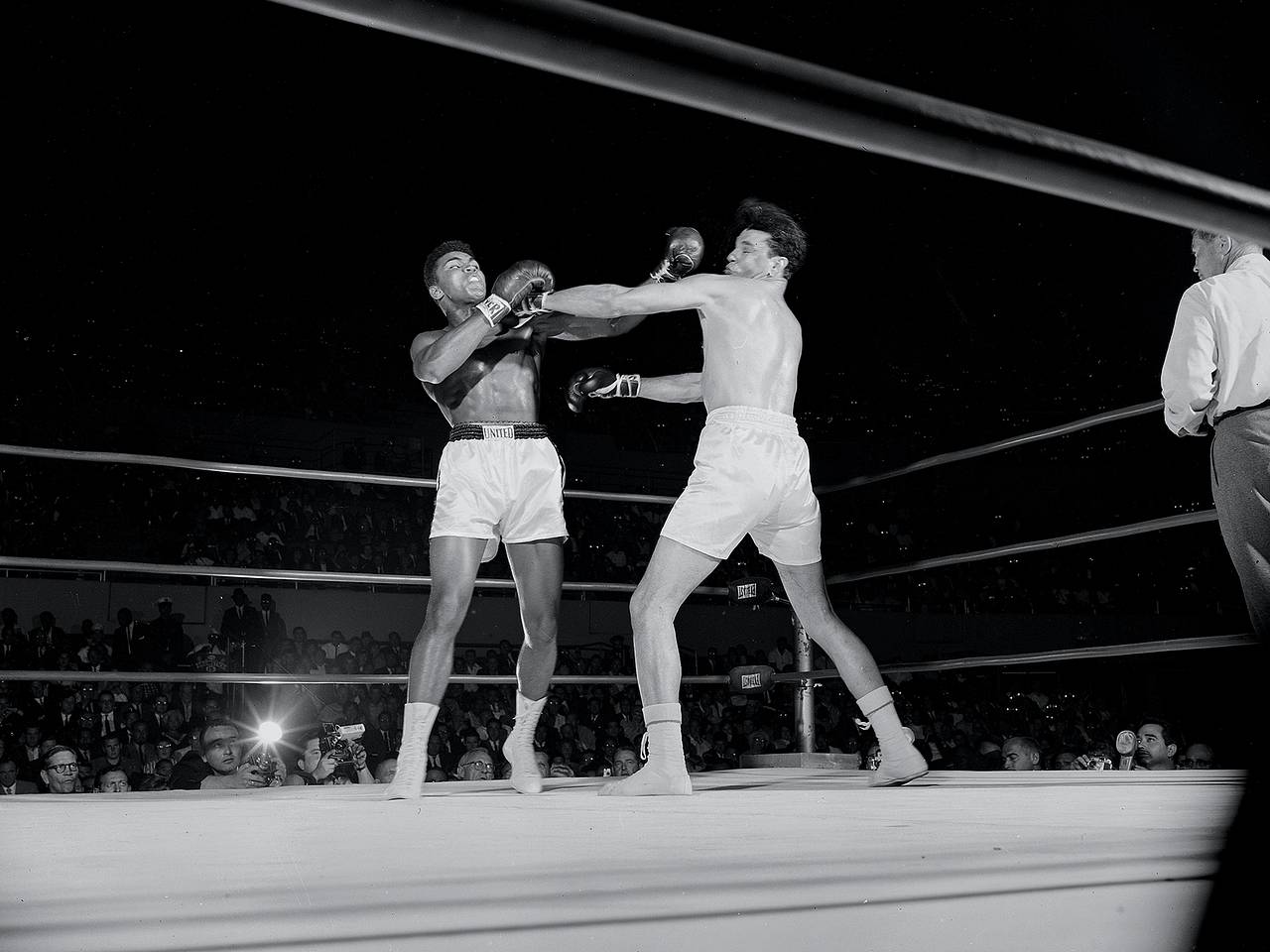 Ali in the ring in front of a press row