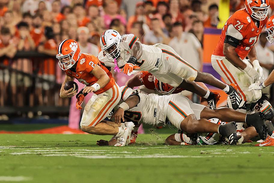 Miami defensive linemen Herbert Scroggins III (31) and Ahmad Moten Sr. (99) combine to sack Clemson QB Tait Reynolds.