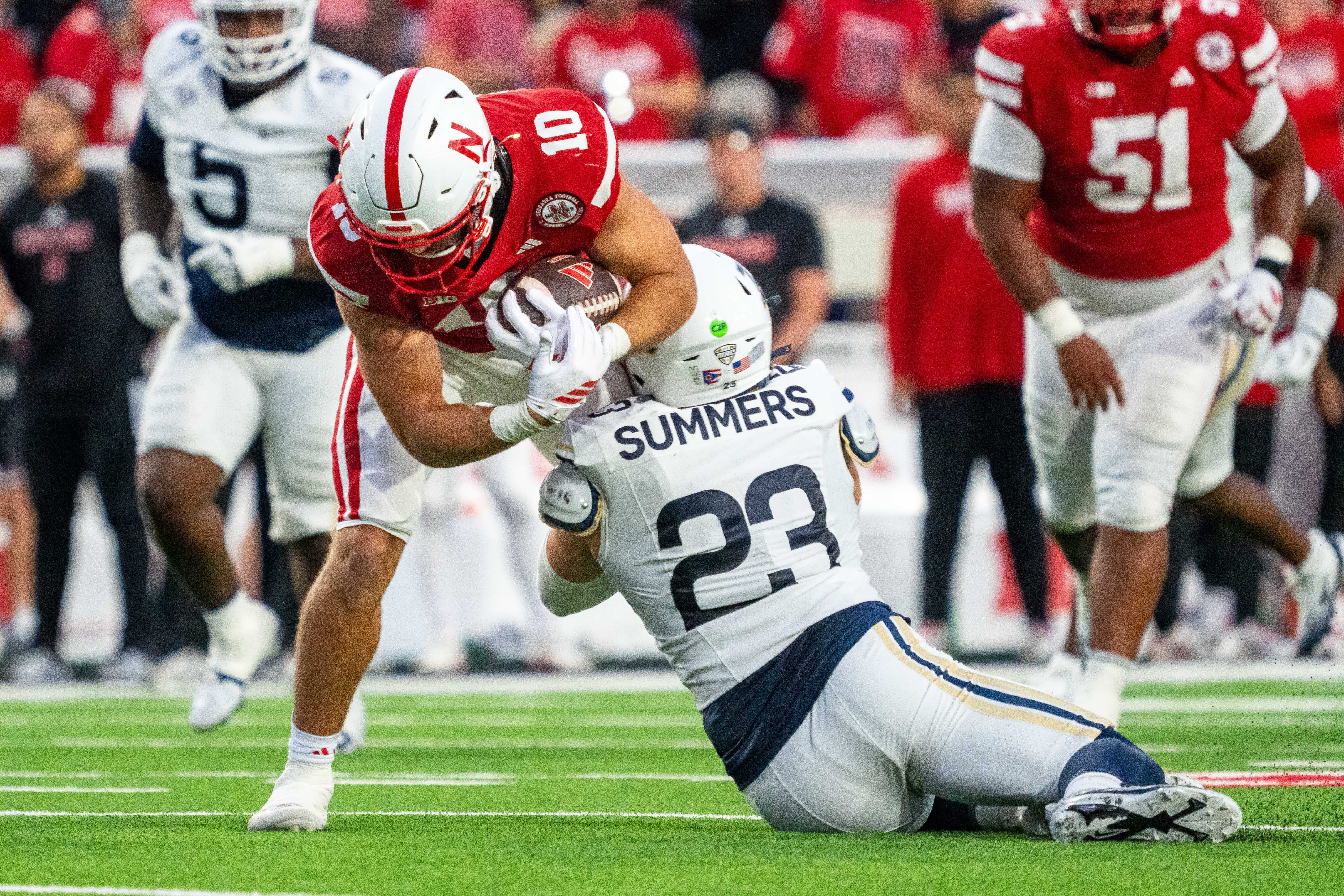 Nebraska tight end Heinrich Haarberg is tackled by Akron linebacker Gage Summers during the second quarter.