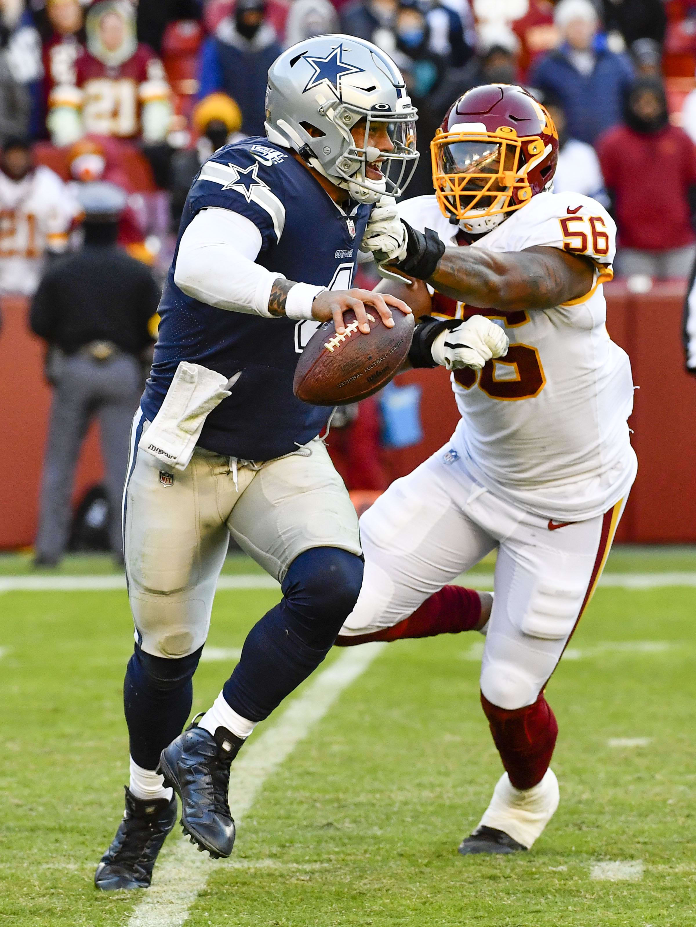 Dallas Cowboys quarterback Dak Prescott avoids the tackle by Washington Football Team defensive end Will Bradley-King 