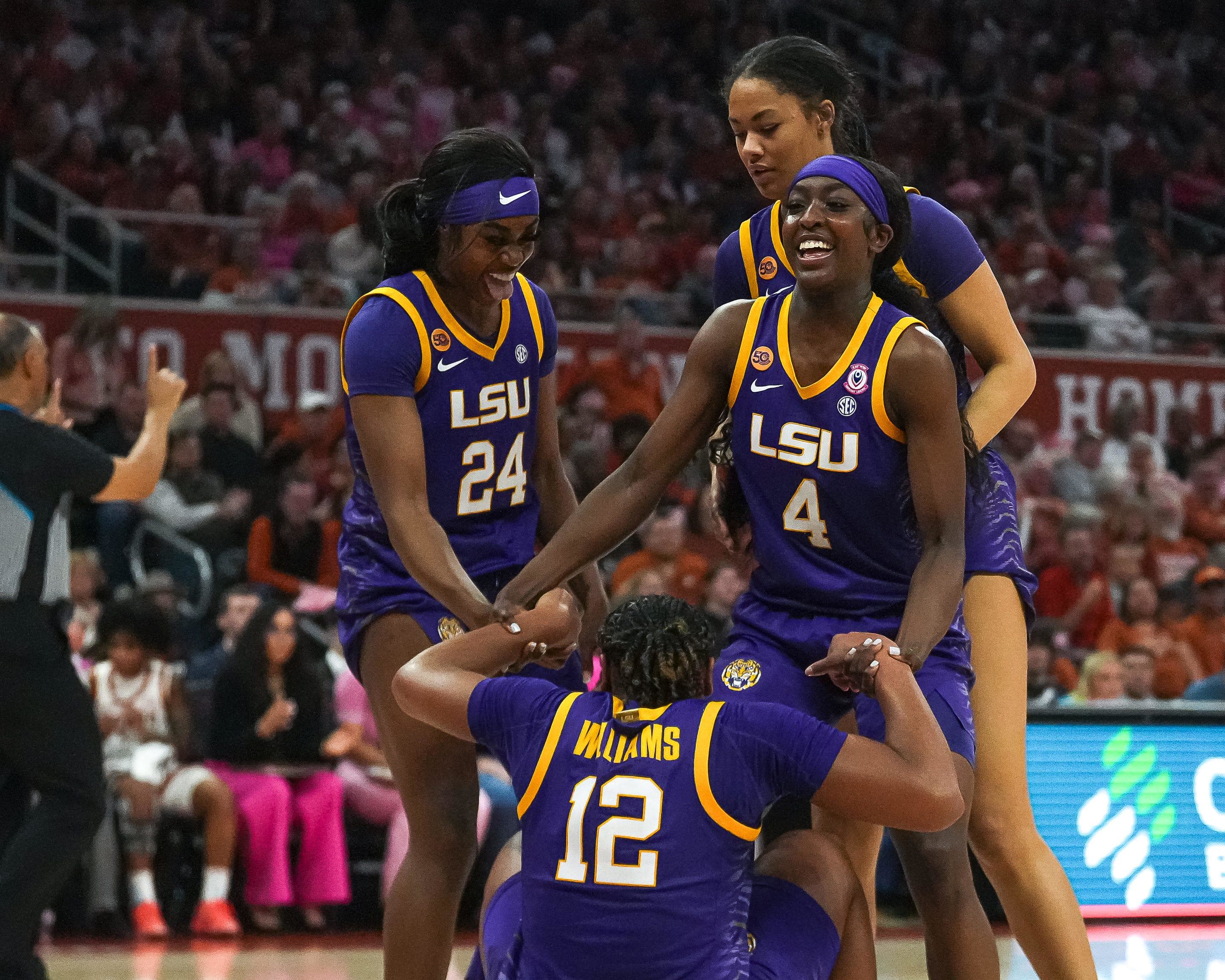 LSU guard Flau'Jae Johnson helps up guard Mikaylah Williams after drawing a foul during the game against the Texas Longhorns.