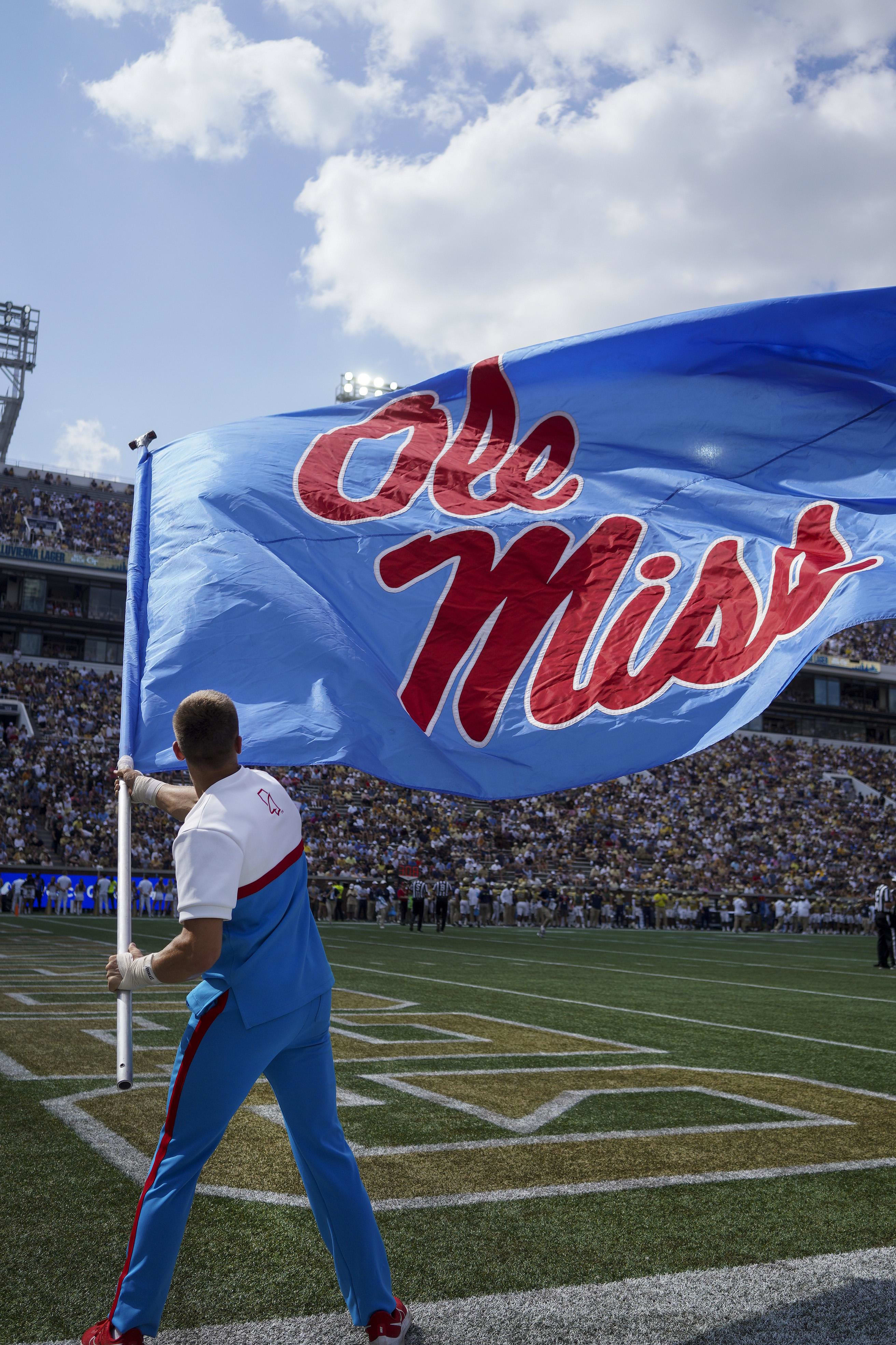 Mississippi Rebels cheerleader waves a flag after a touchdown against the Georgia Tech Yellow Jackets