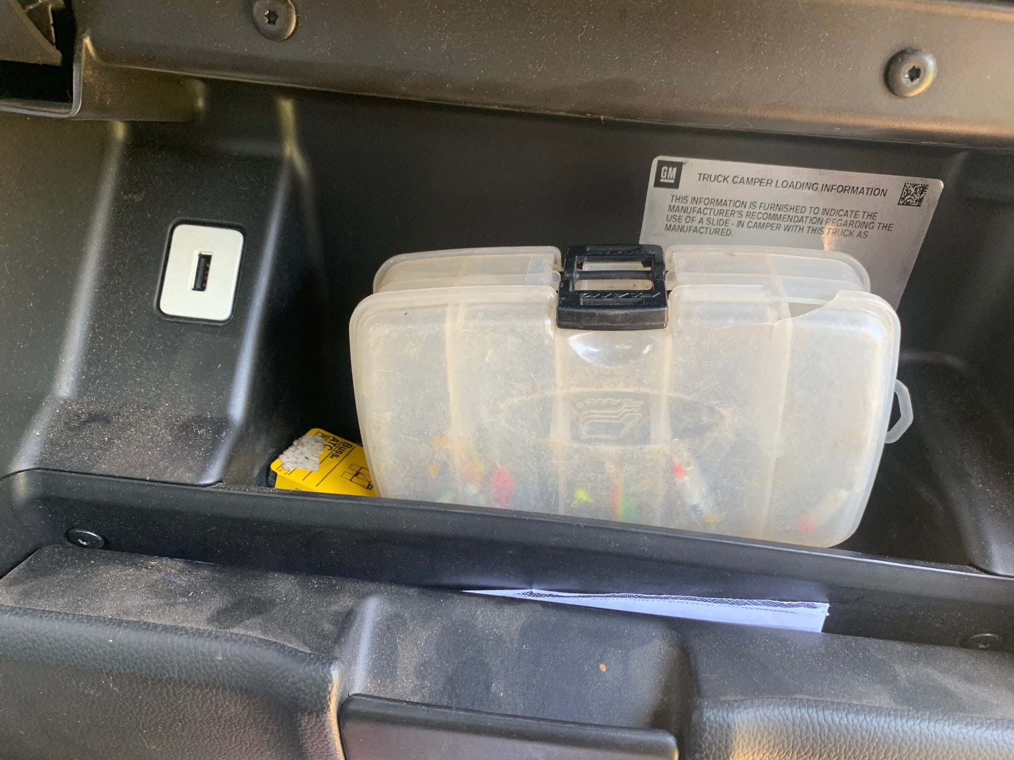 A small tackle box in a glove compartment.