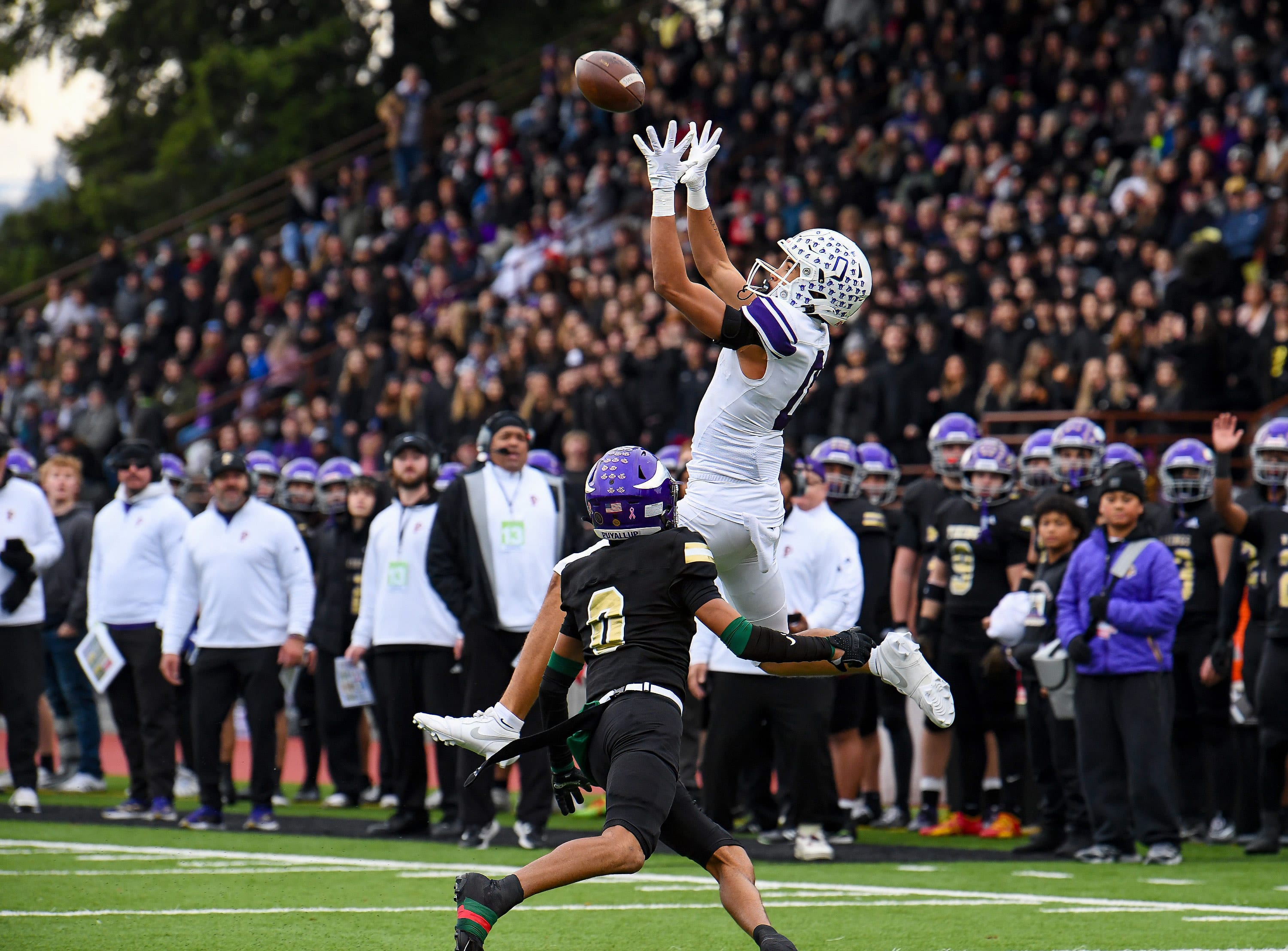 Sumner’s Braylon Pope goes up high for the grab over Puyallup’s Jason Denmark in a Washington high school football game