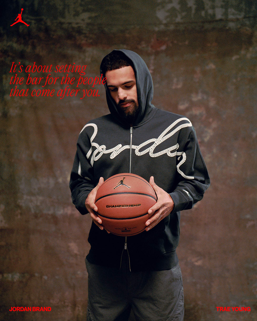 Trae Young holds a basketball in a photo shoot.