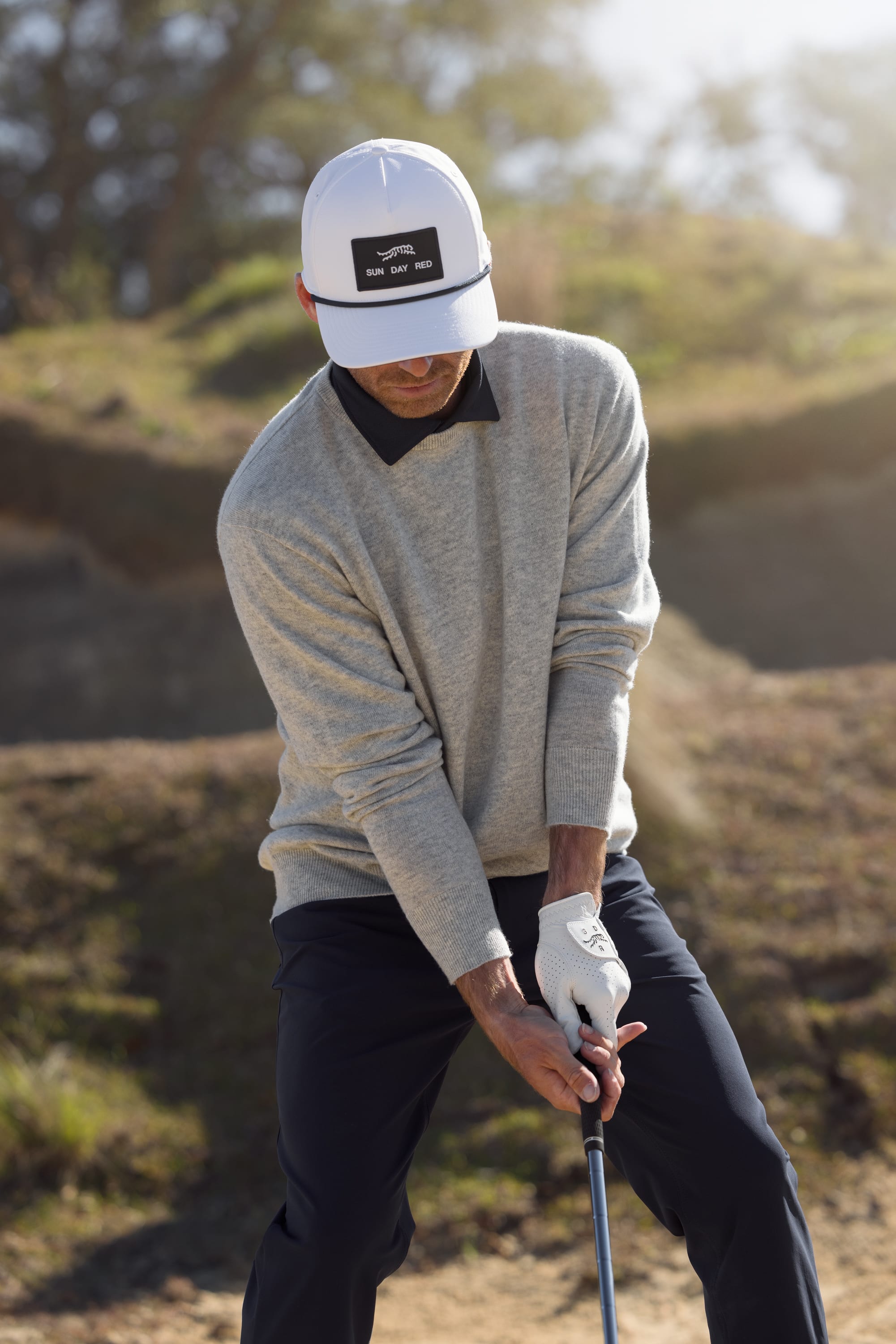 A golfer models Sun Day Red apparel.