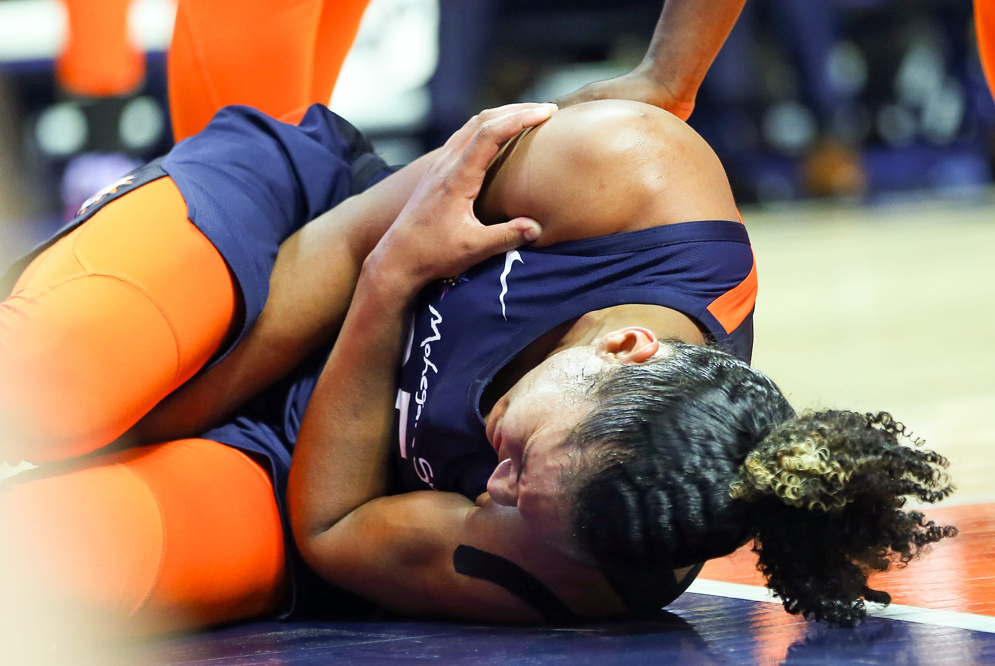 Sun forward Alyssa Thomas holds her shoulder while laying on the court in pain in 2018.