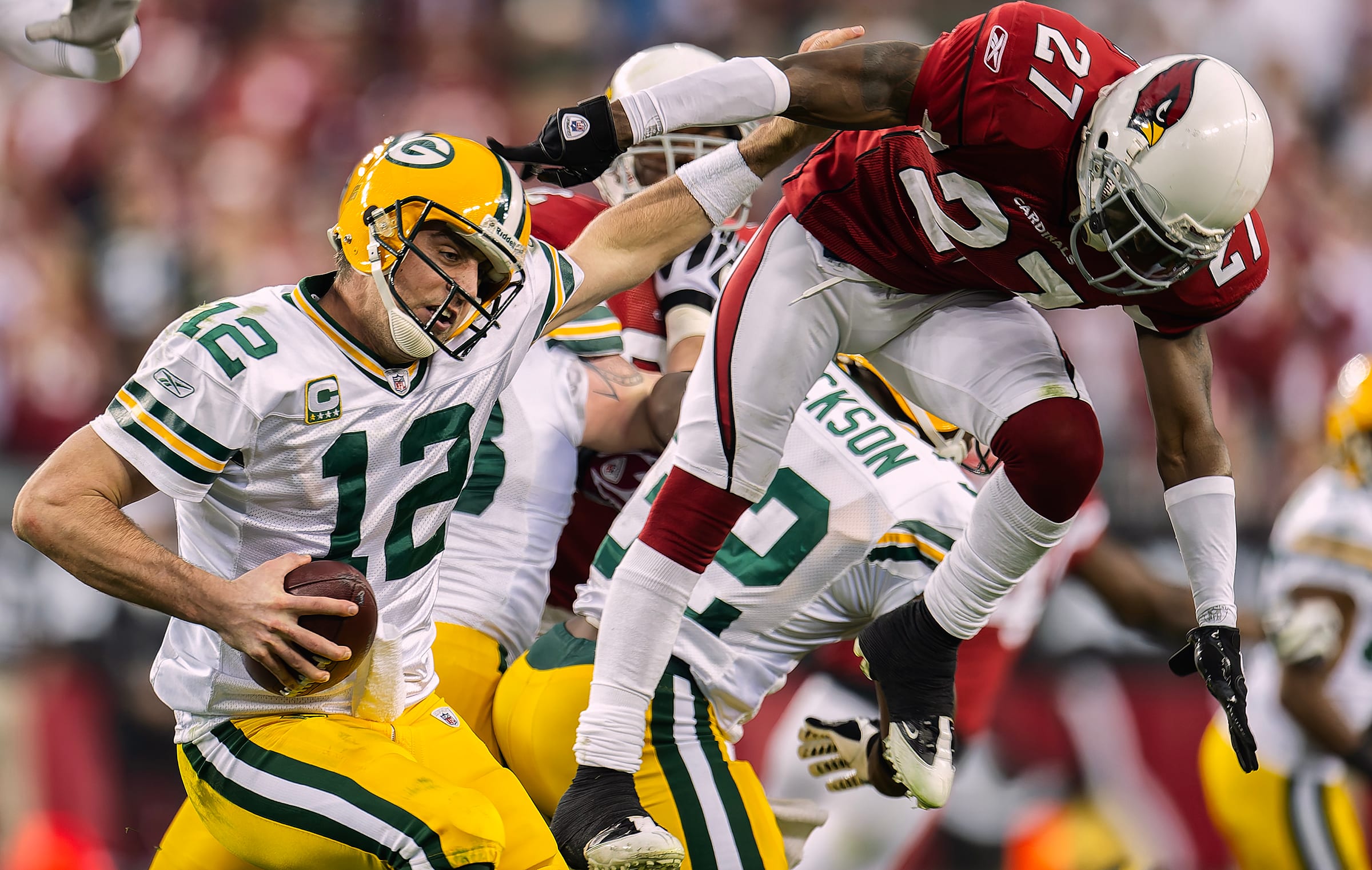 Aaron Rodgers fends off a Cardinals tackler in a playoff game