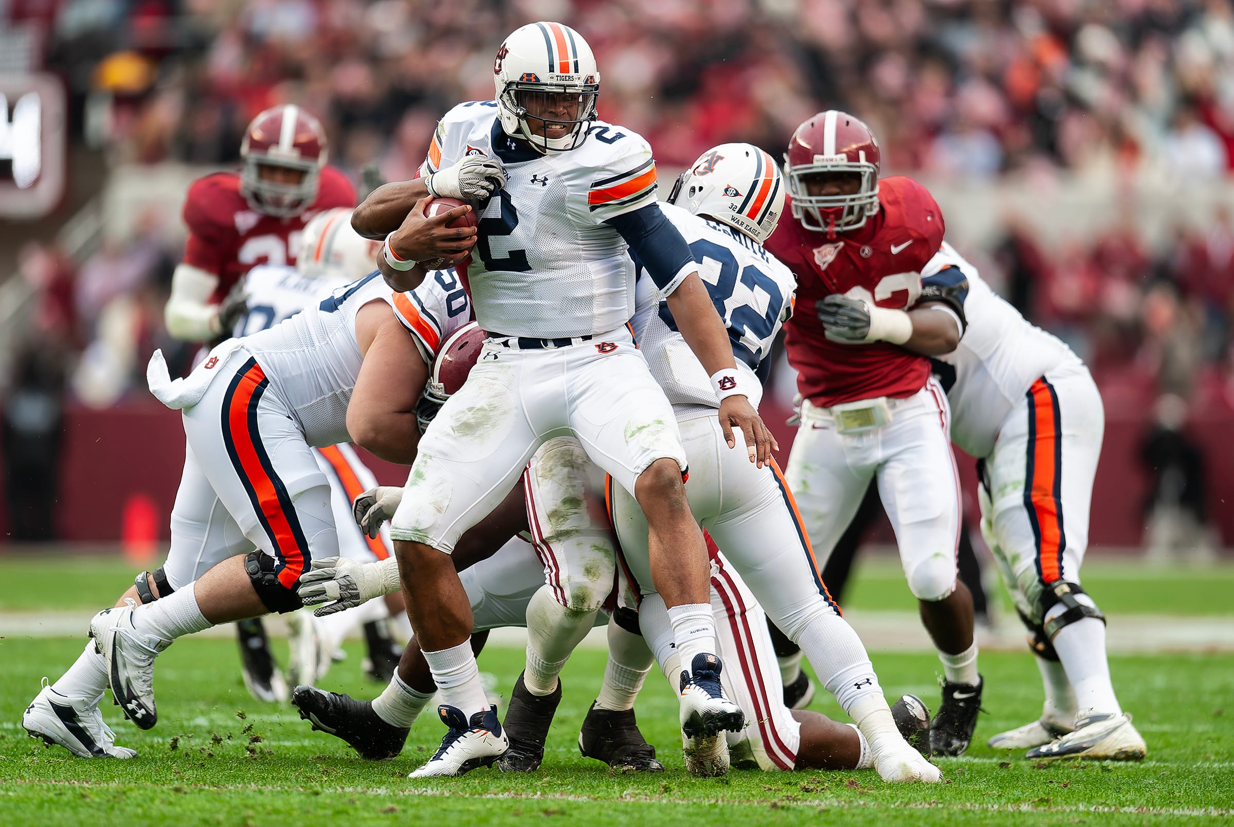 Cam Newton attempts to escape a tackle by Alabama defenders in 2010.