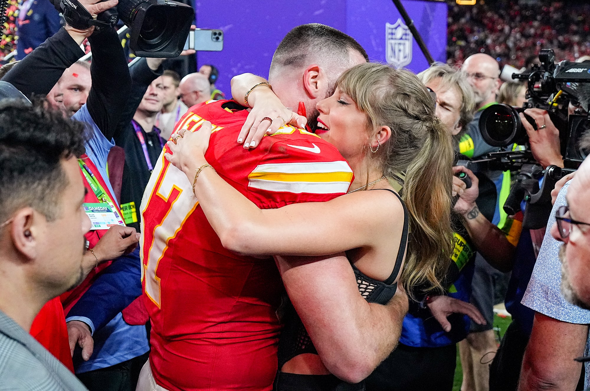 Travis Kelce (87) hugs girlfriend and singer Taylor Swift
