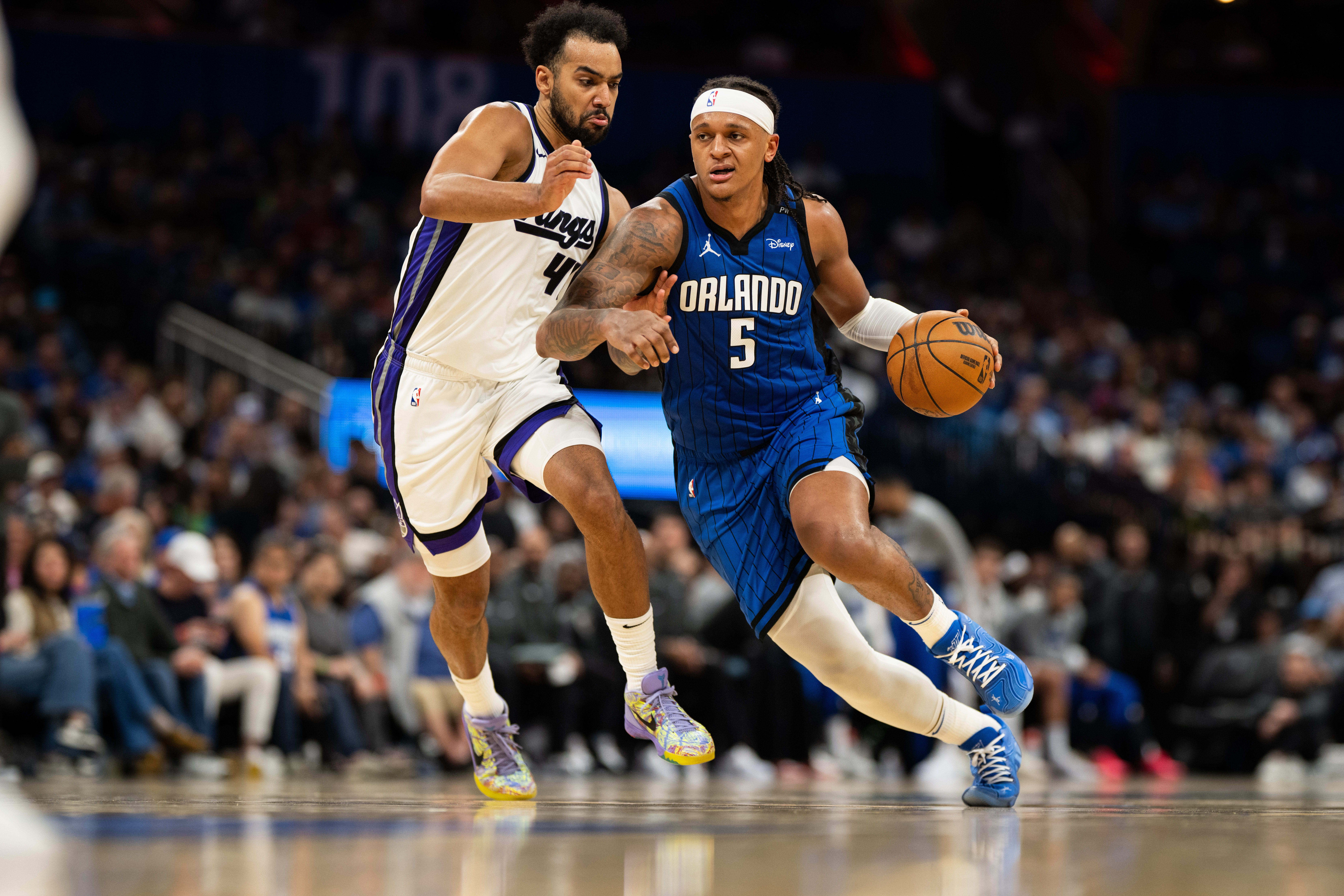 Magic forward Paolo Banchero dribbles past Kings forward Trey Lyles.