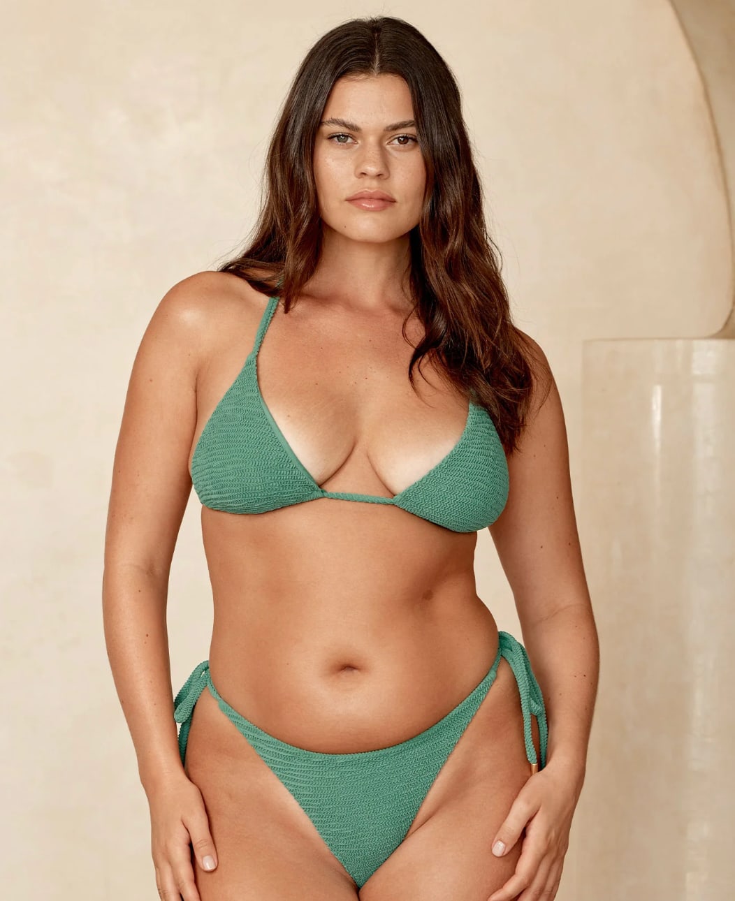 A model poses in a seafoam green crinkle fabric bikini from Monday Swimwear.