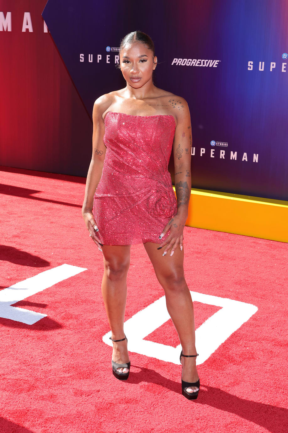 Jordan Chiles wears a red dress and black heels on the red carpet.