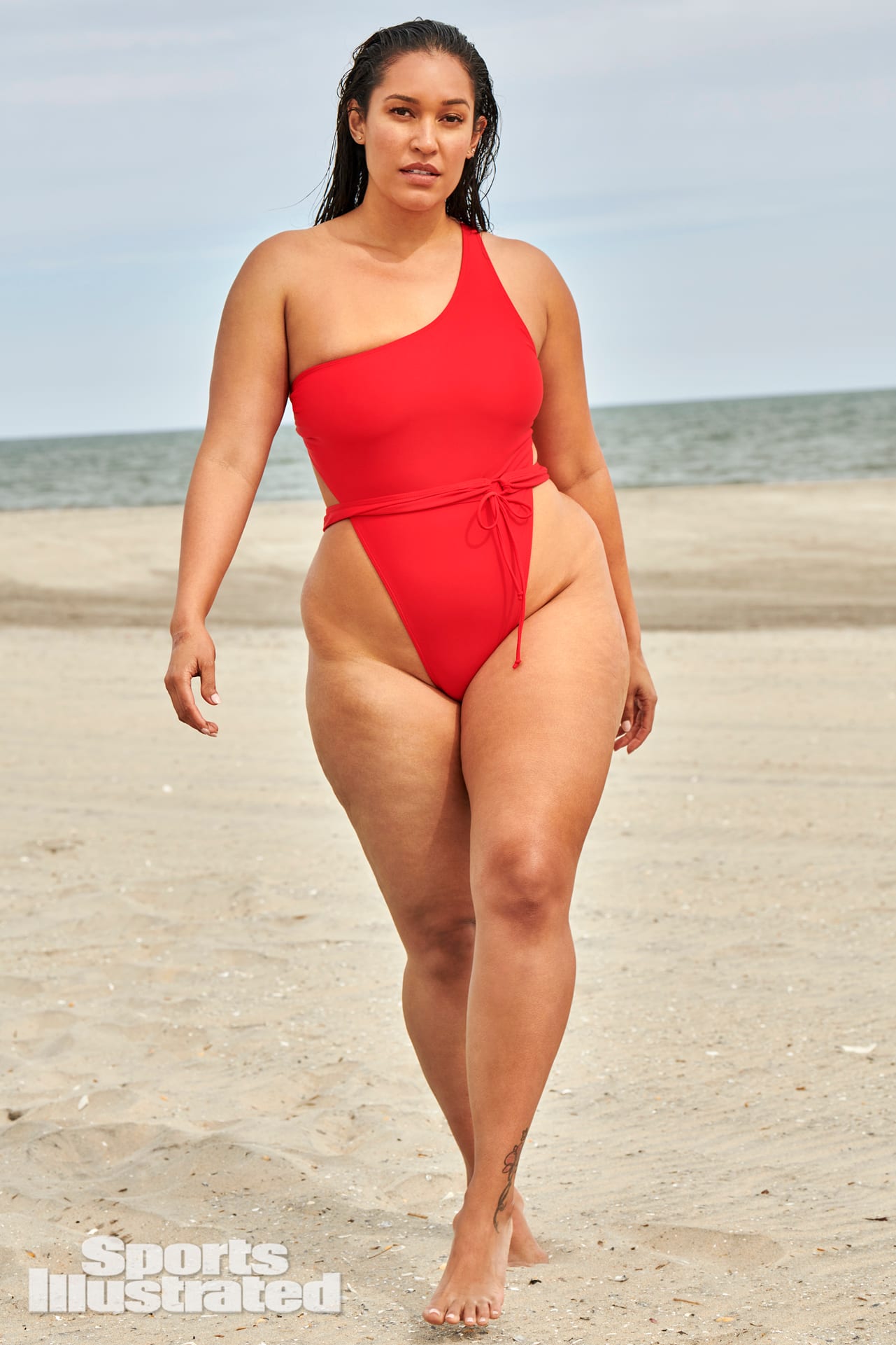 Amanda Kay is wearing a bright red one piece swimsuit.
