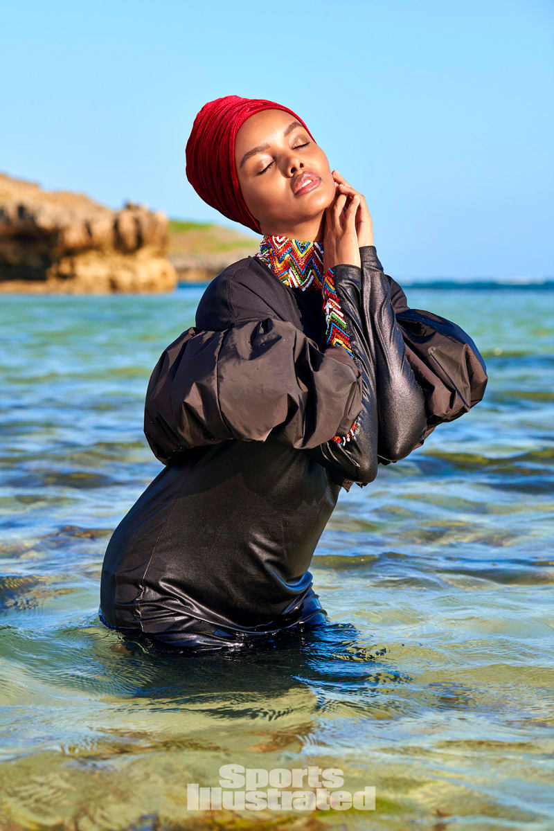 Halima Aden is wearing a black burkini and red headpiece in Kenya.