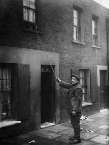 A knocker-up in London in 1929.