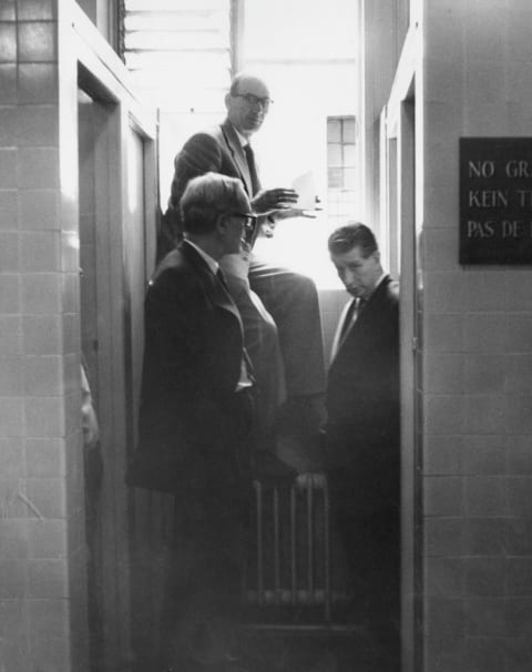 Detectives search the men's bathroom where the thief was thought to have entered and escaped.