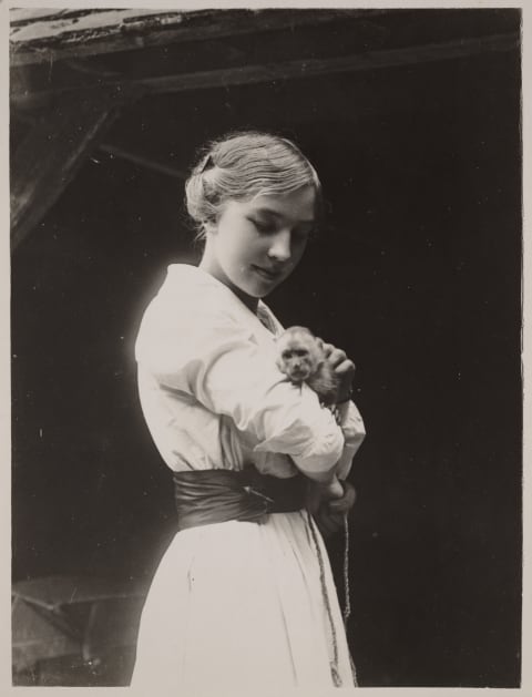 A young woman poses with her pet monkey.