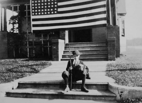 Young boy in front of his home on Armistice Day November, 11, 1918.