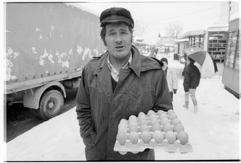 Street Vendor Holding Carton of Eggs