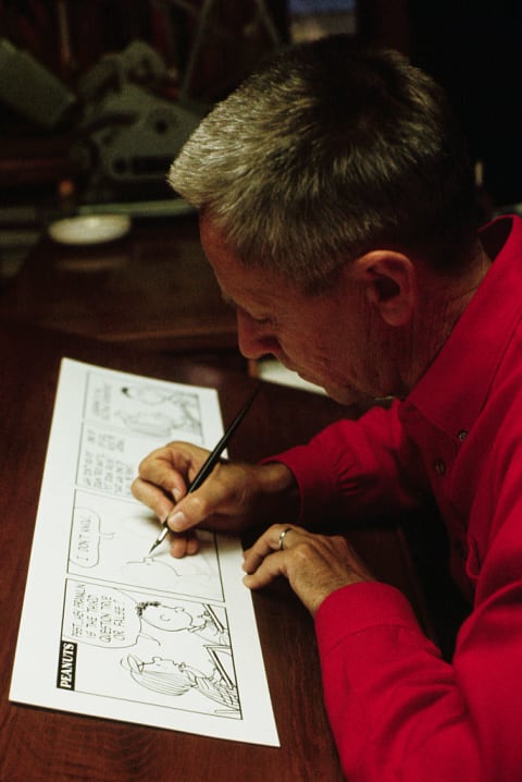 Charles Schulz working on a comic strip.