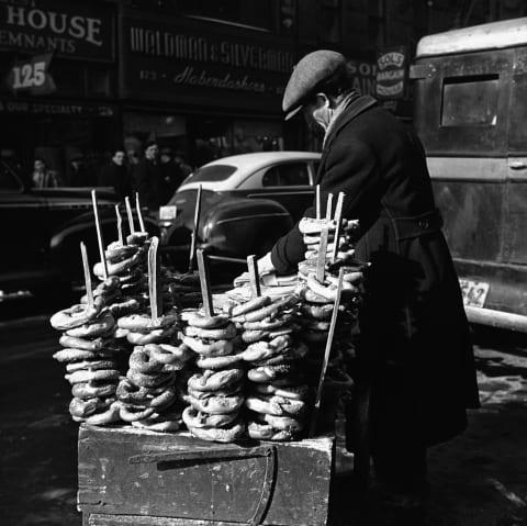 A street vendor setting up his cart to sell pretzels.