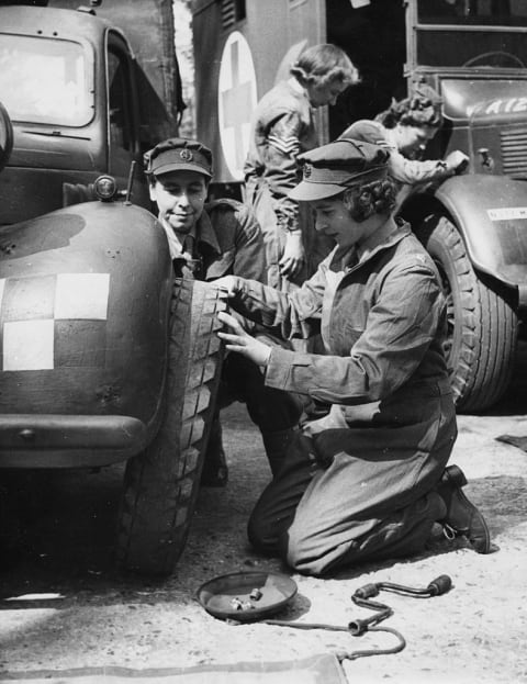 Then-Princess Elizabeth changing the tire of a vehicle during training.